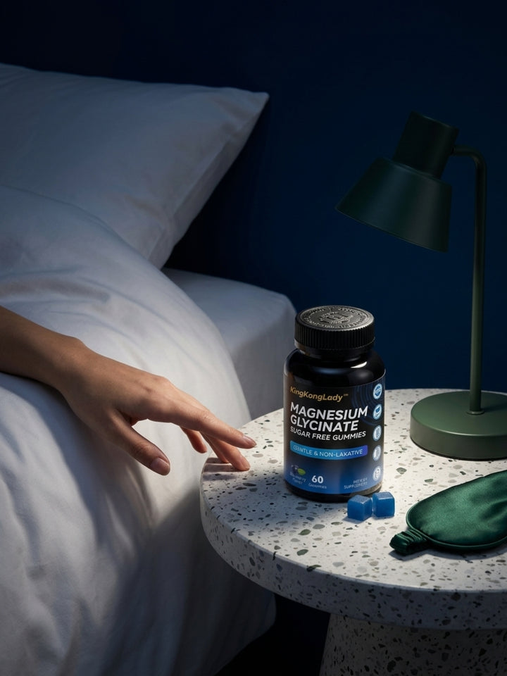 KingKongLady magnesium glycinate gummies on a bedside table beside a lamp and sleep mask.