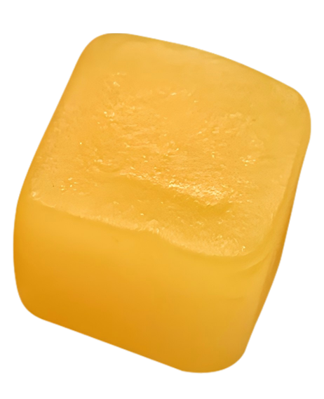 Close-up of a yellow cube-shaped gummy viewed at an angle.